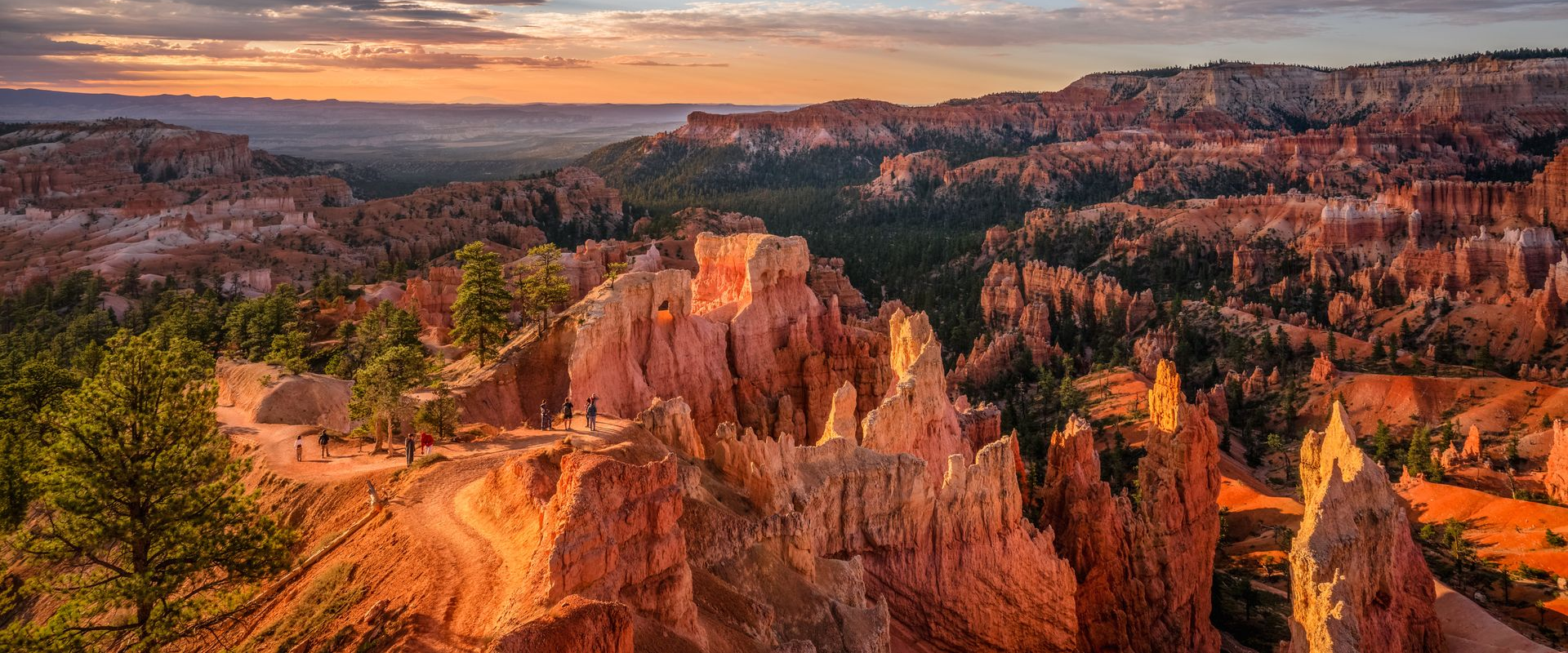 A group of people standing next to each other on top of a mountain.
