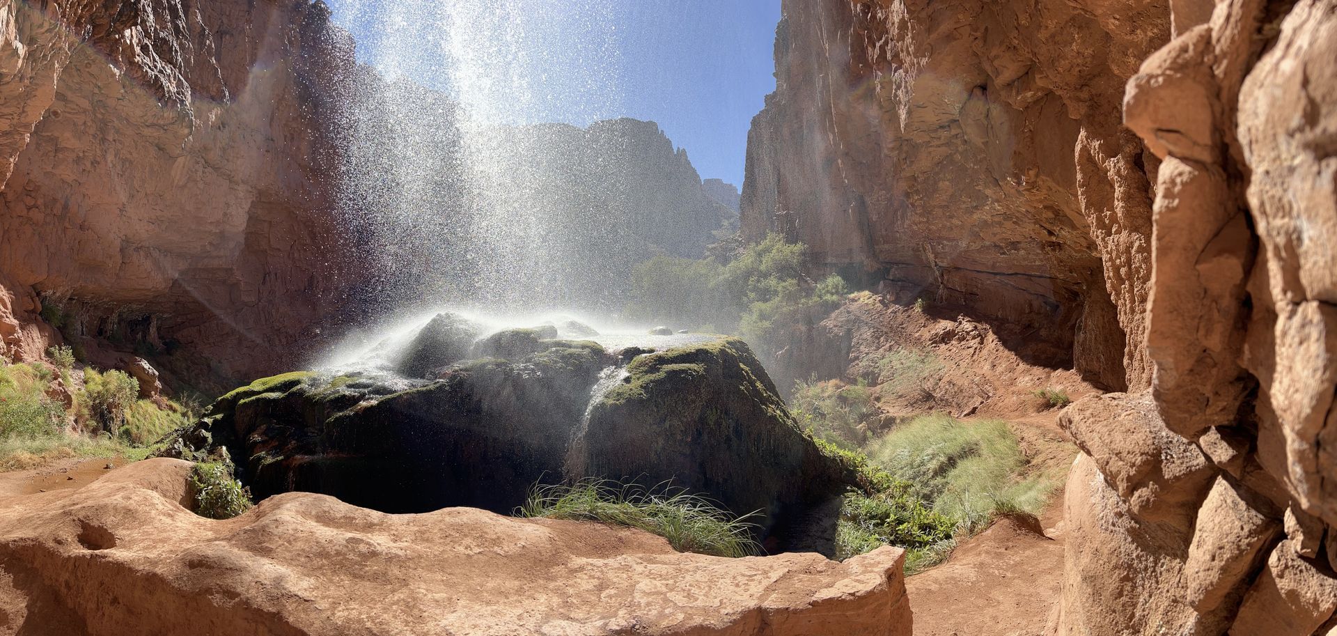 There is a waterfall in the middle of a canyon.