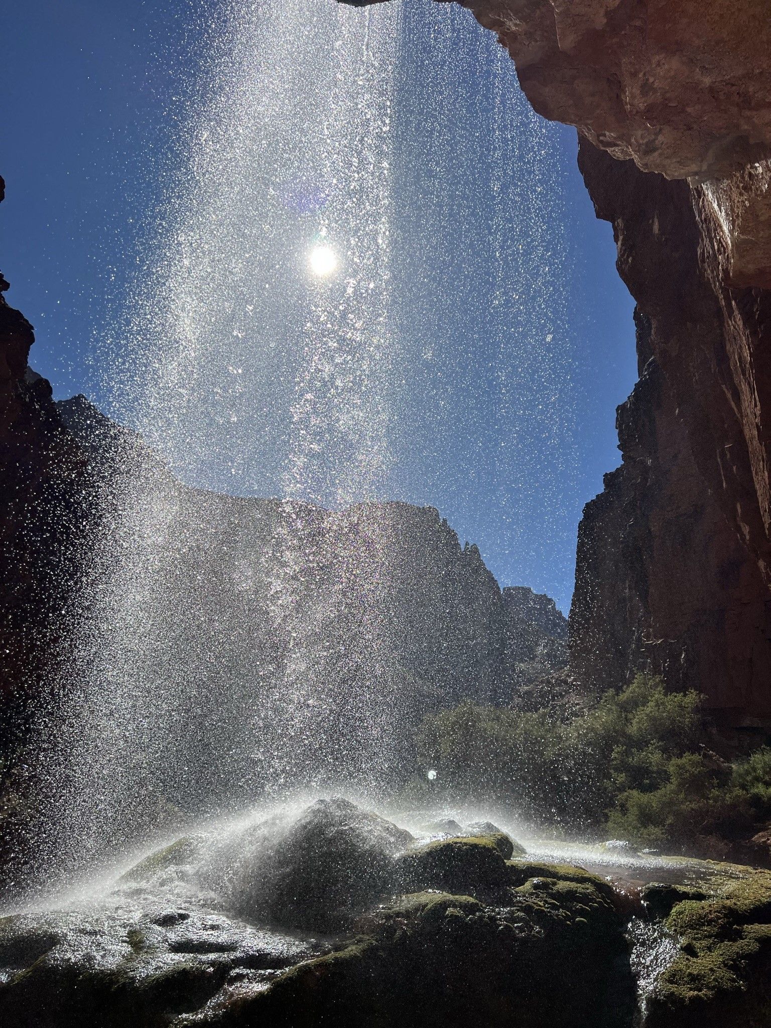A waterfall with the sun shining through it