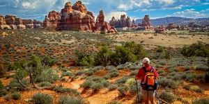 A person is hiking in the desert with a backpack.