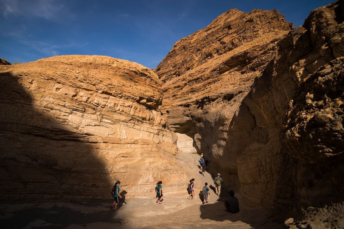 People hike through a large rock formation