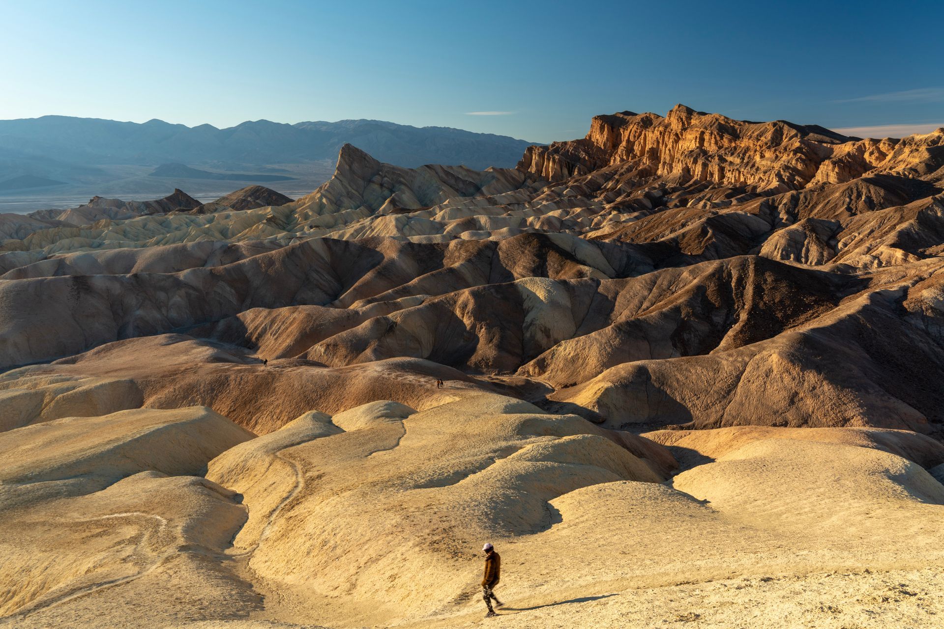 A person walks in solitude along a barren landscape