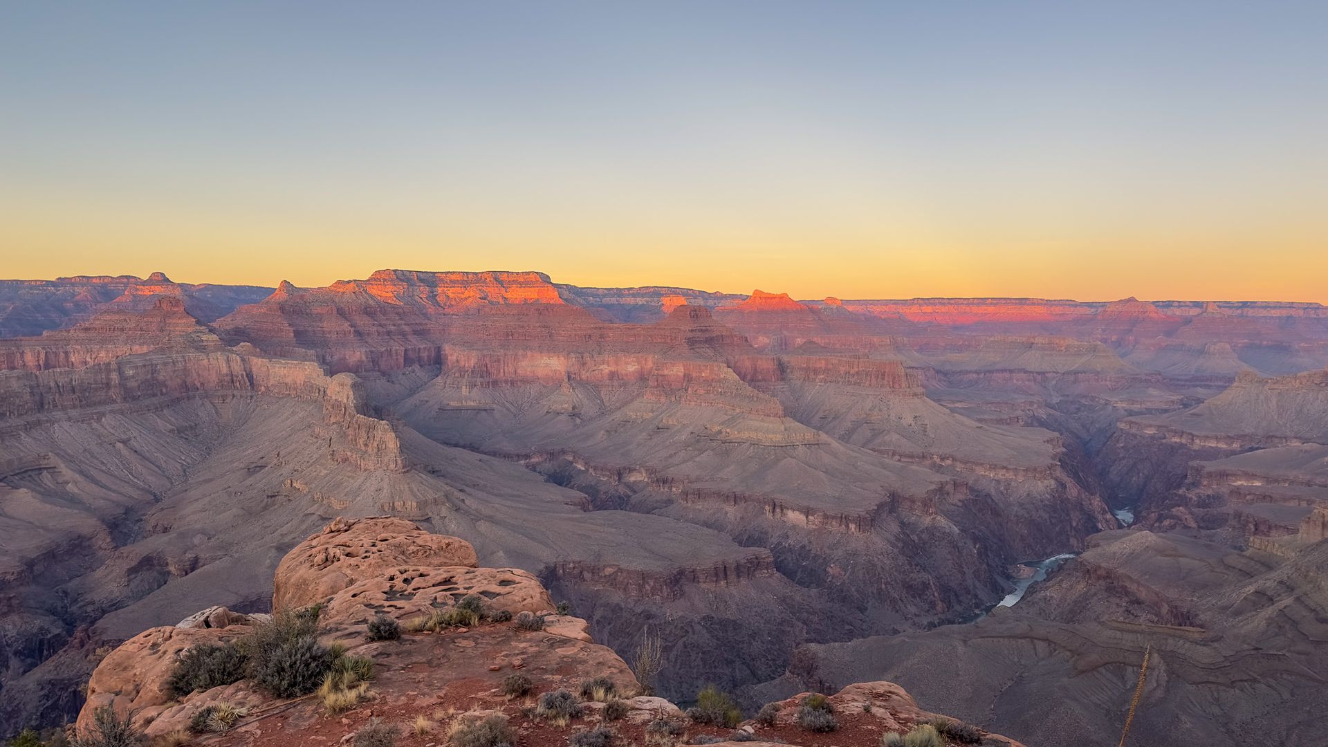Grand Canyon at sunset, with layers of rock bathed in orange and blue hues.