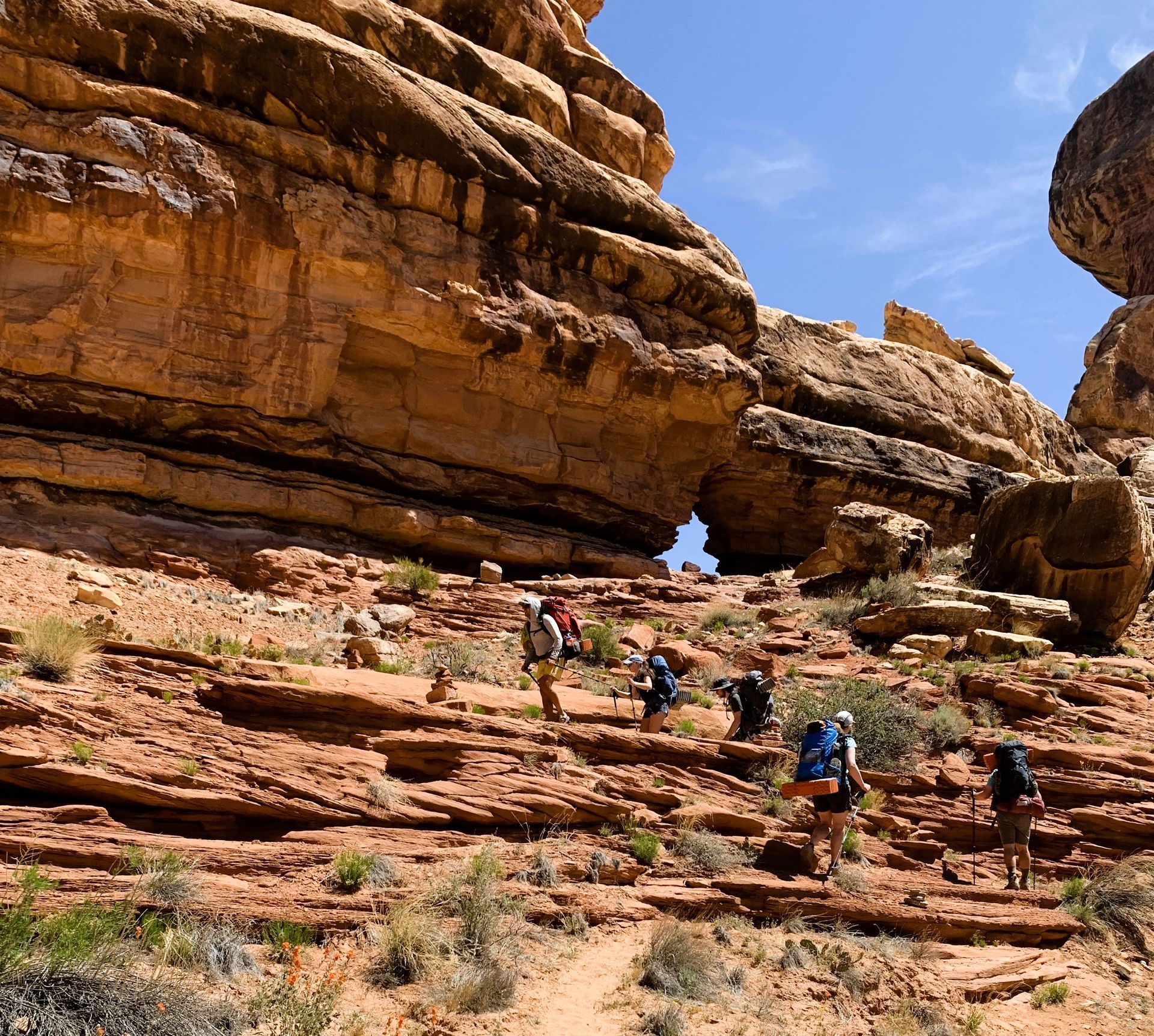 A group of people hiking up a rocky hillside