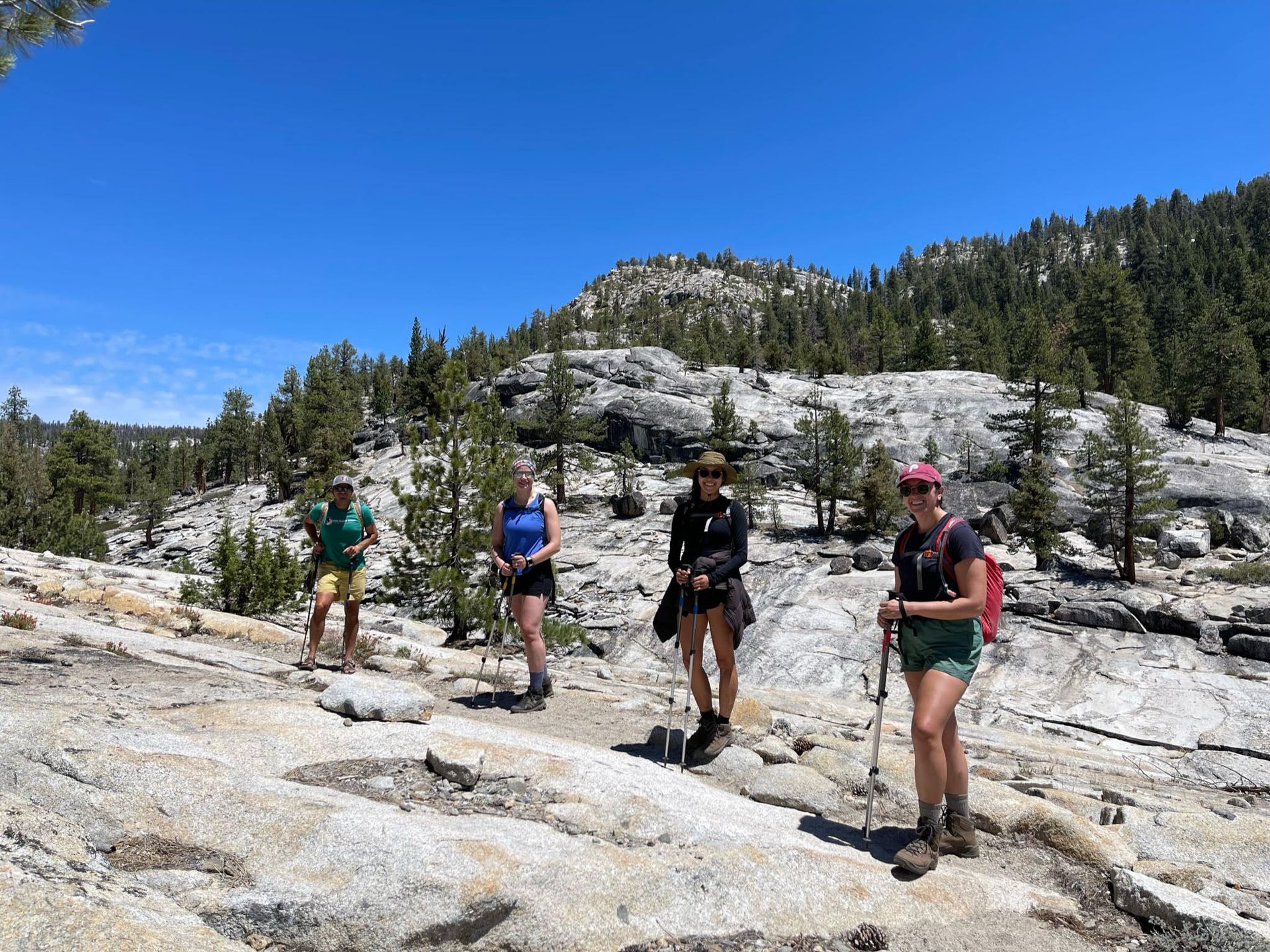 A group of people are standing on top of a rocky mountain.