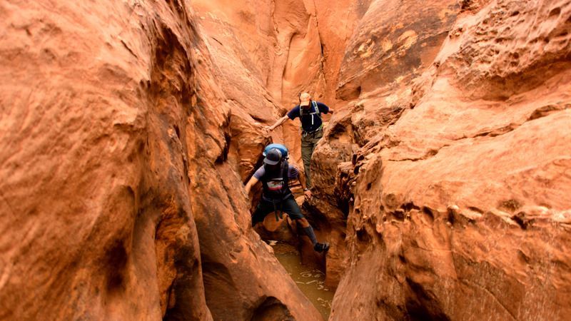 A group of people standing next to each other on top of a mountain.