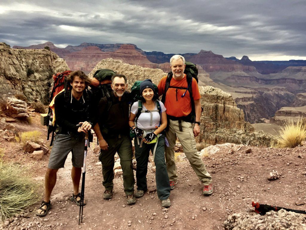 A group of people are posing for a picture on top of a mountain.