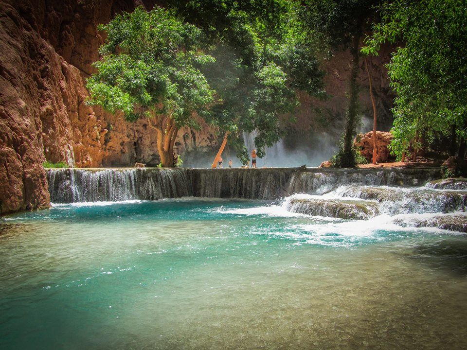 People swim in aqua colored water of the Grand canyon