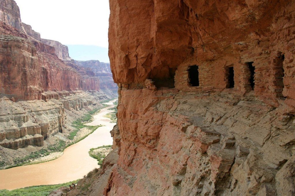 A river flowing through a canyon with a cliff in the foreground