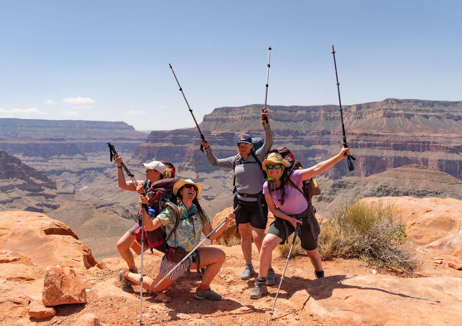 A group of women are posing for a picture on top of a mountain.