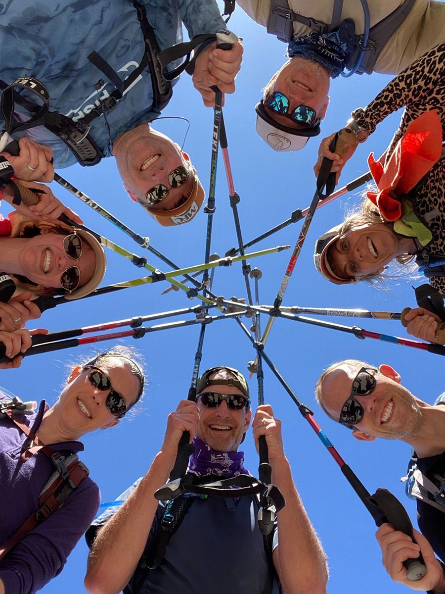 A group of people holding hiking poles in a circle