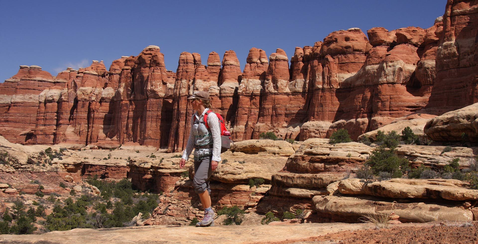 A person is hiking in the desert with a backpack.