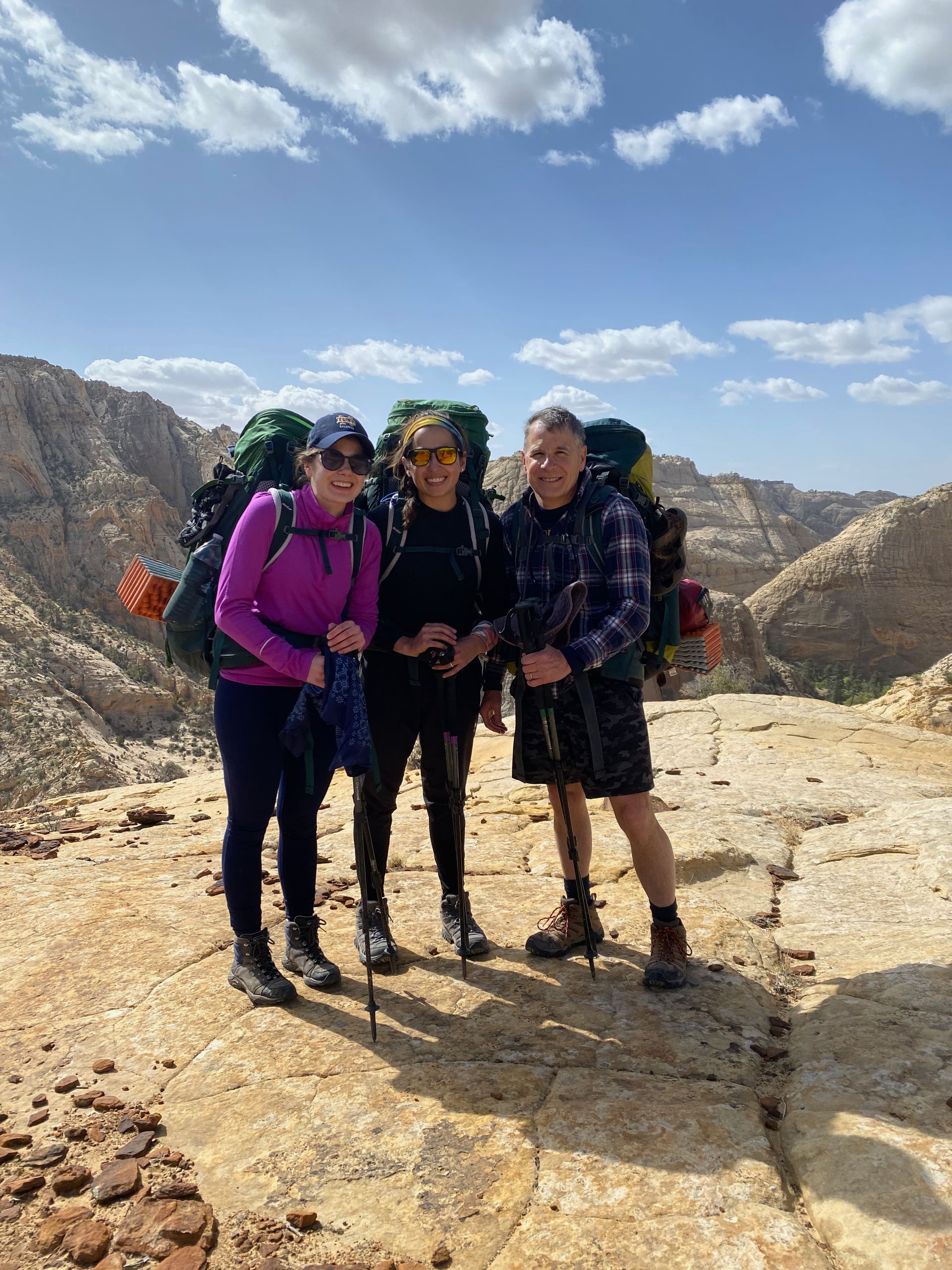 A group of people standing next to each other on top of a mountain.