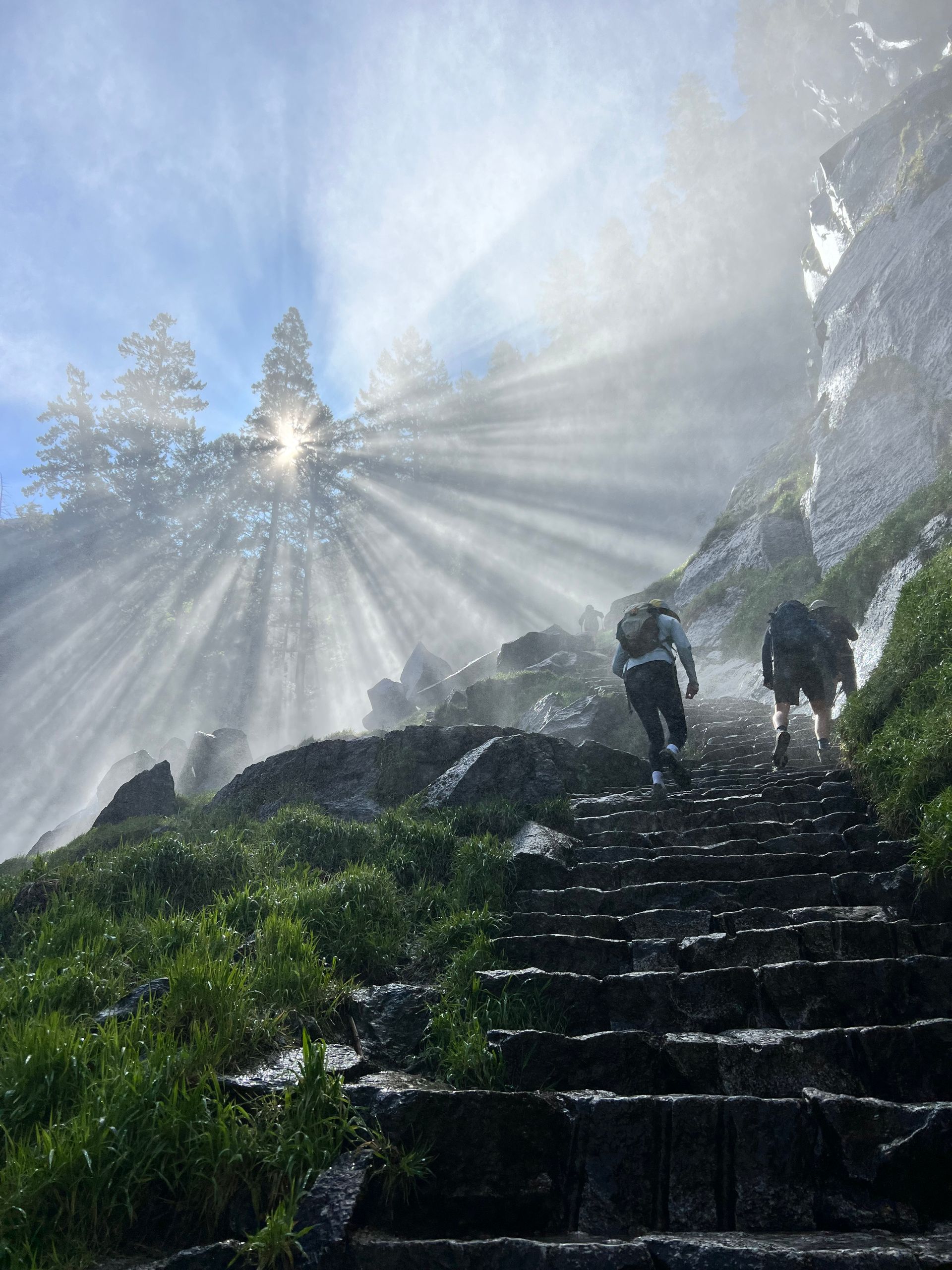A couple of people are walking up a set of stairs in the mountains.