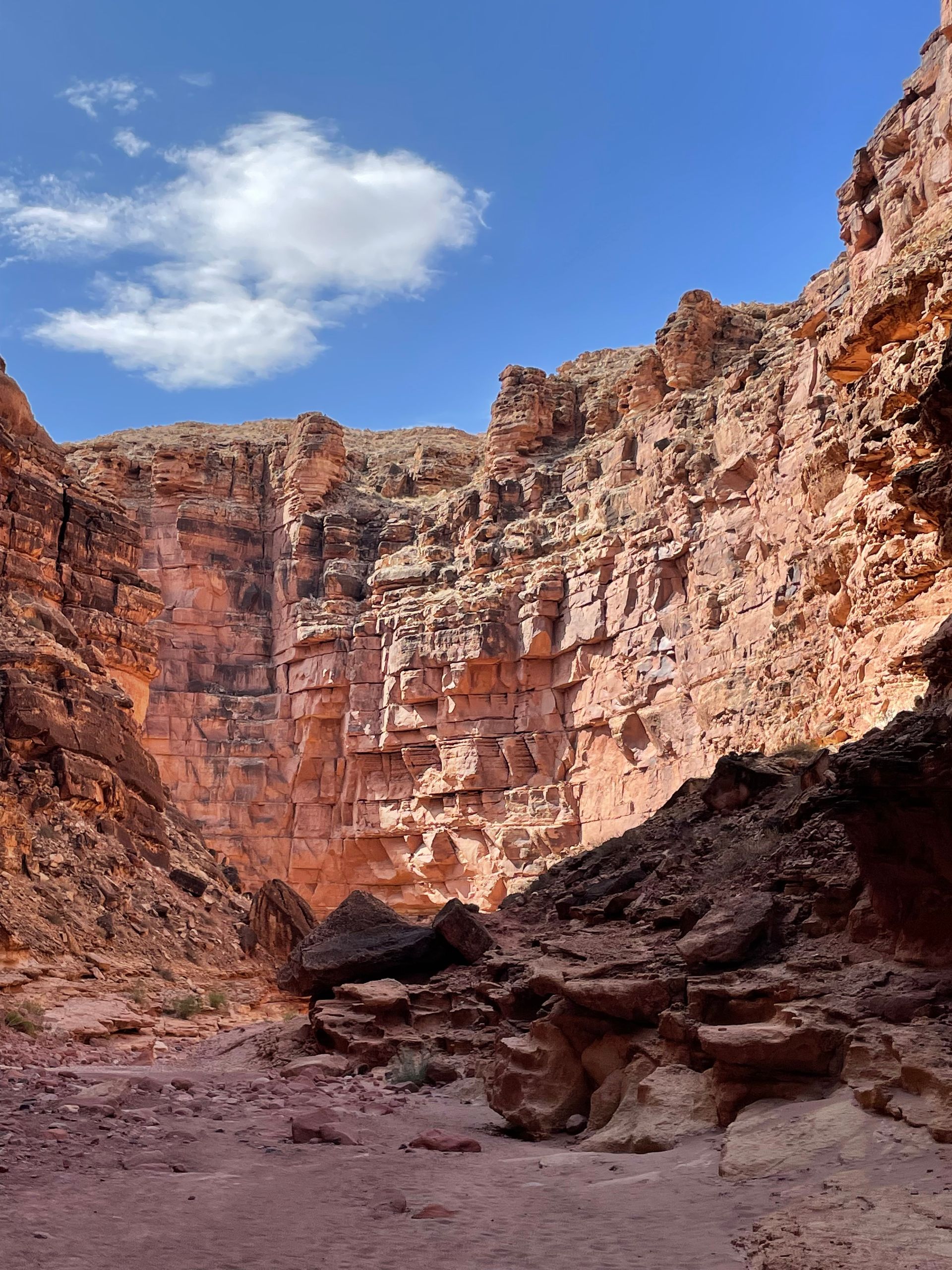 A canyon with a blue sky and clouds in the background