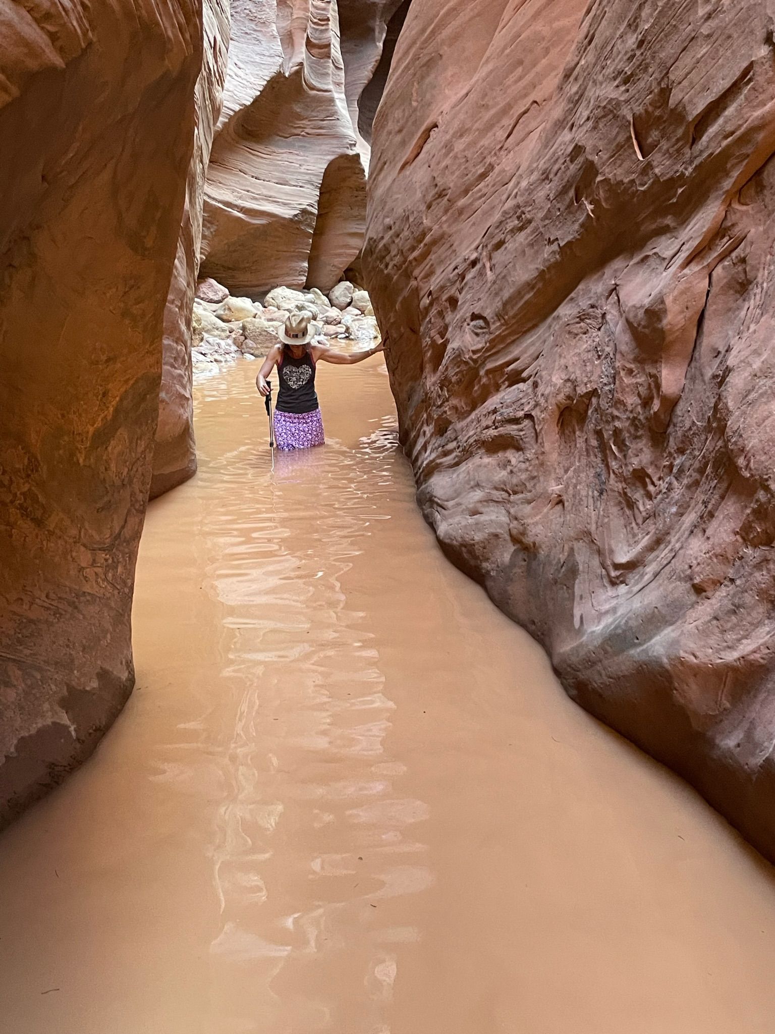 A person is walking through a canyon filled with water.