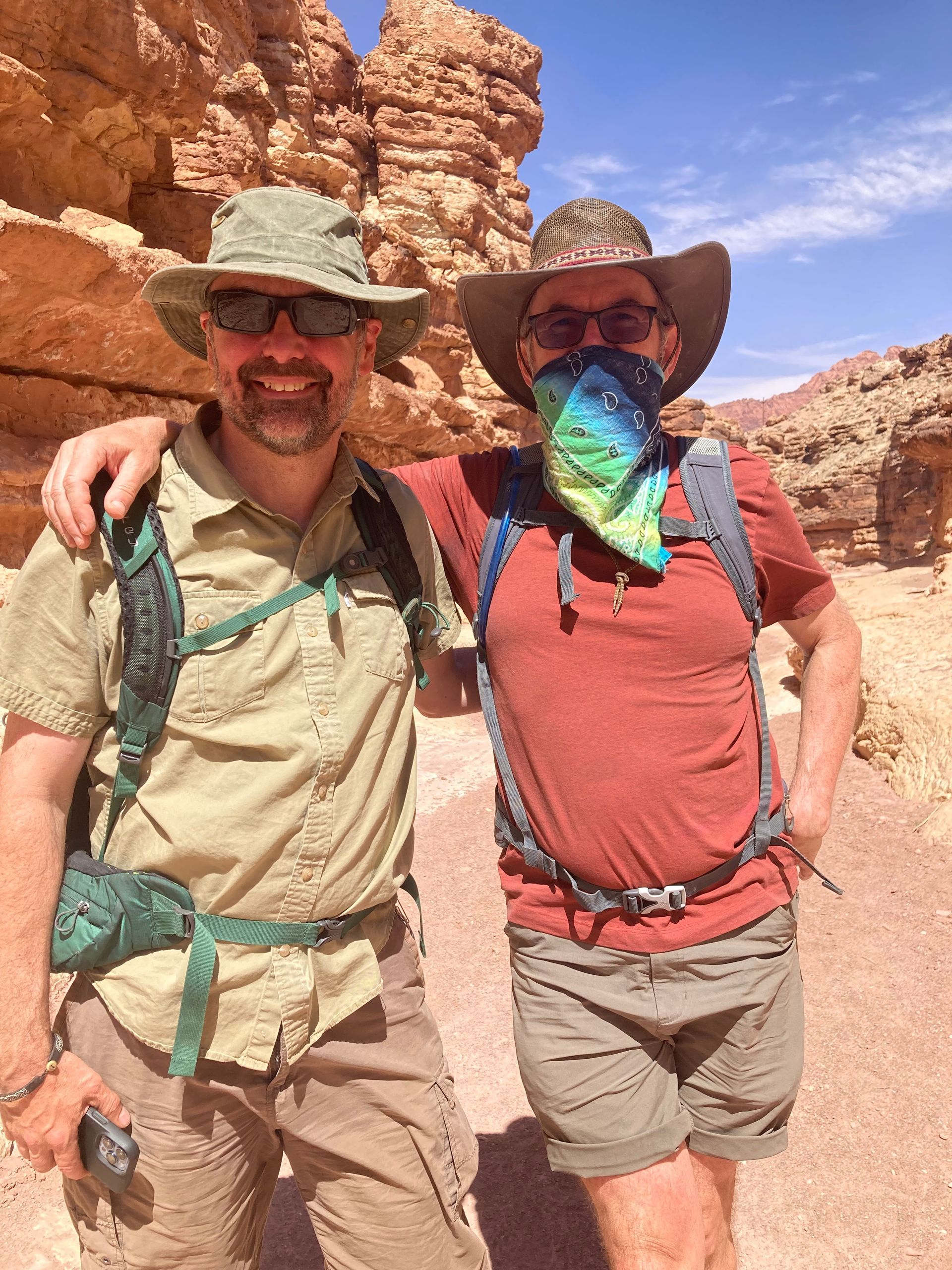 Two men are standing next to each other in the desert.