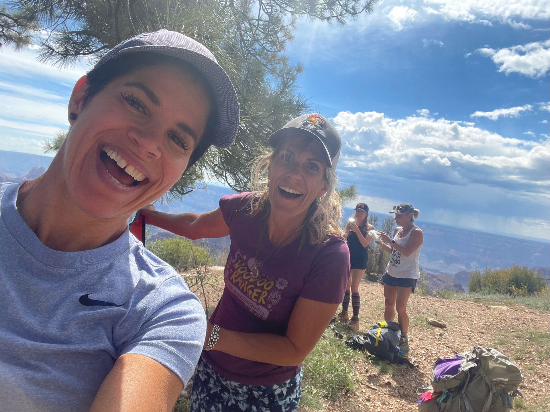 A group of people are taking a selfie on top of a mountain.