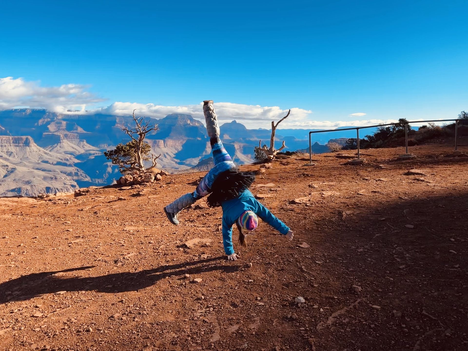 A person is doing a handstand on top of a dirt hill.