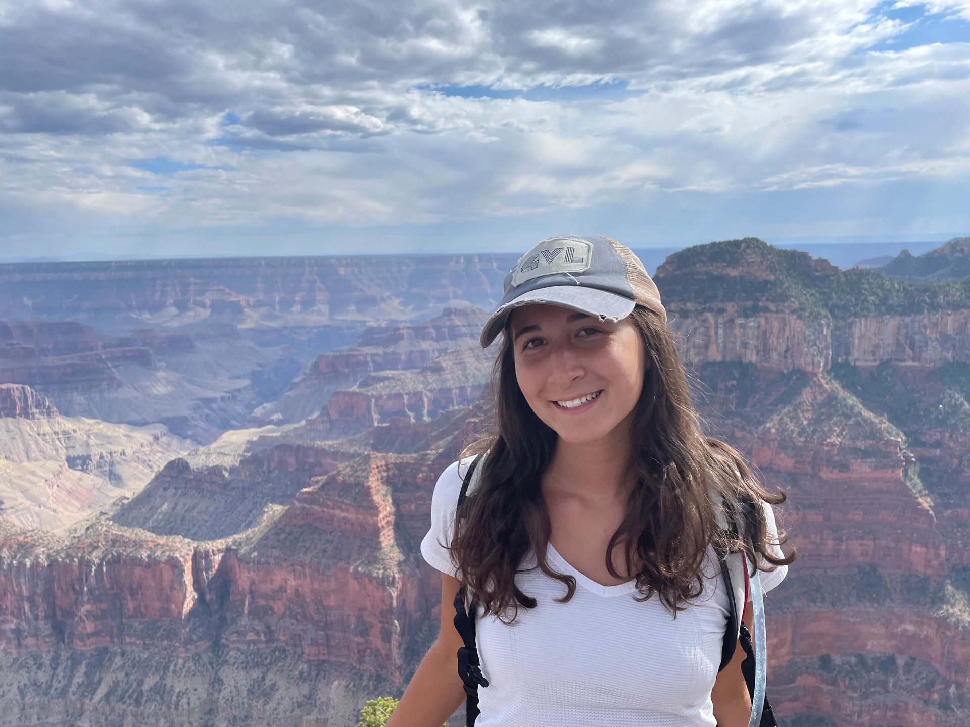 A woman is standing in front of a grand canyon.