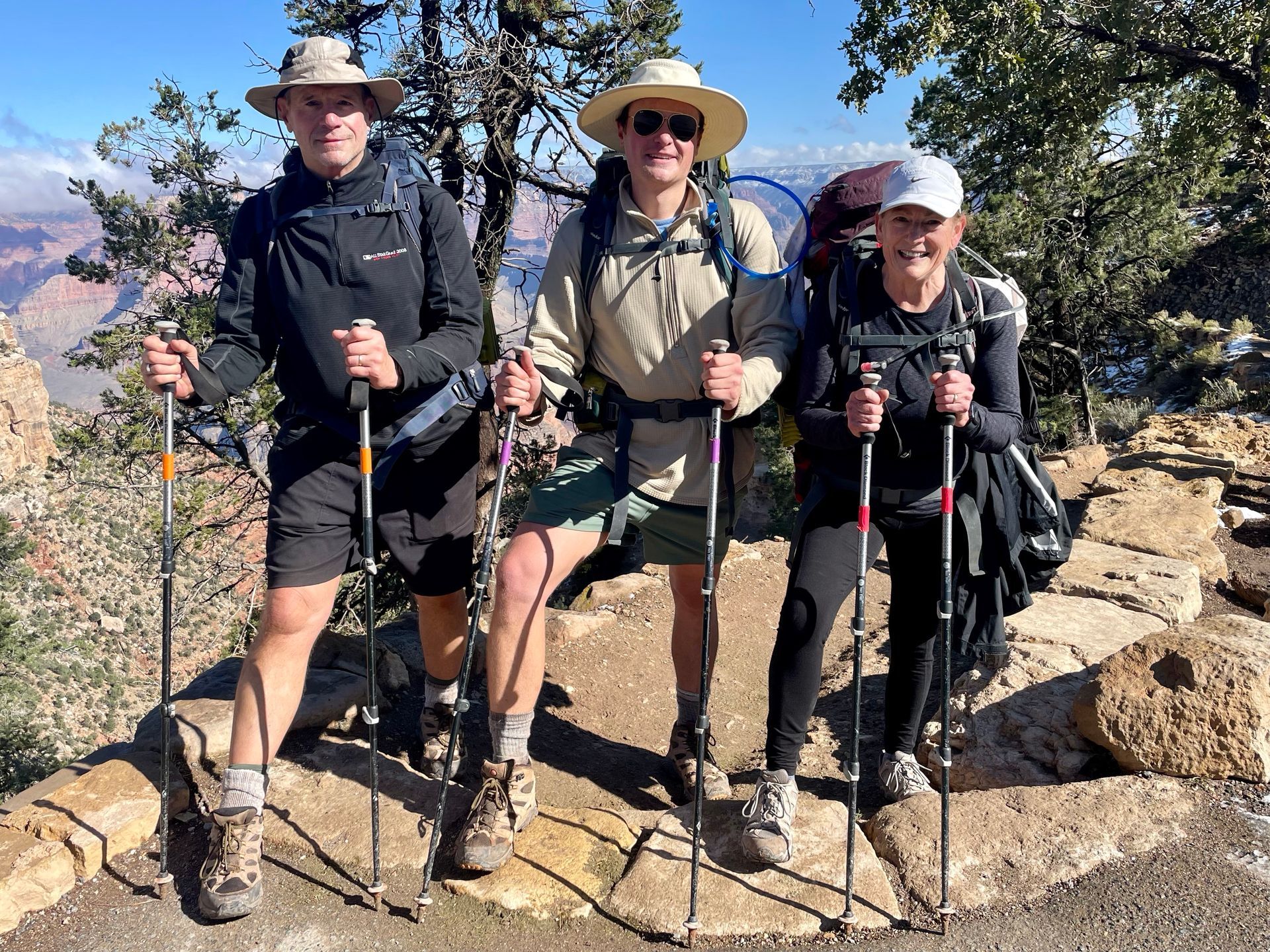 People smiling along a hike and wearing backpacks