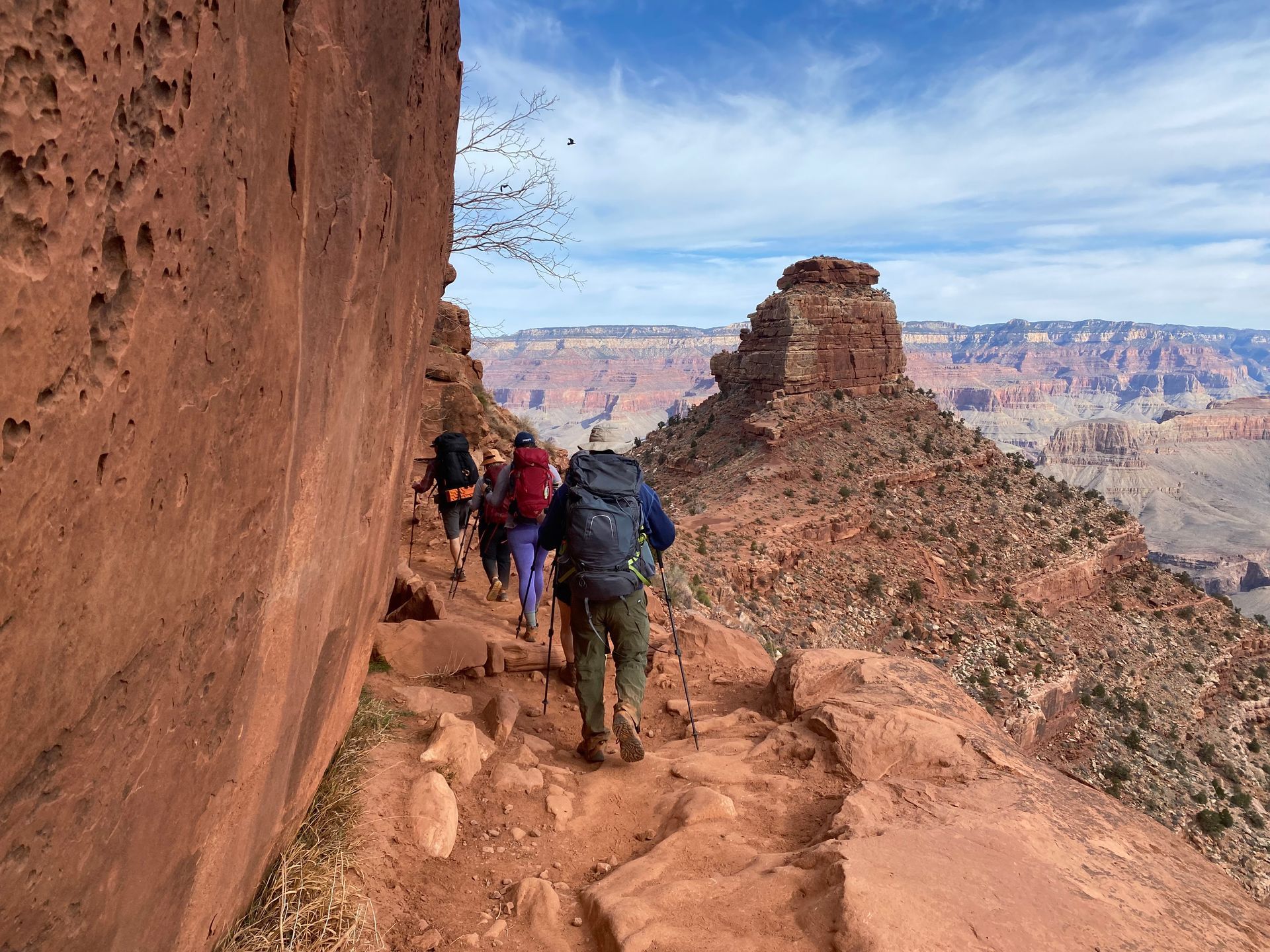 A group of people are hiking up a rocky trail.