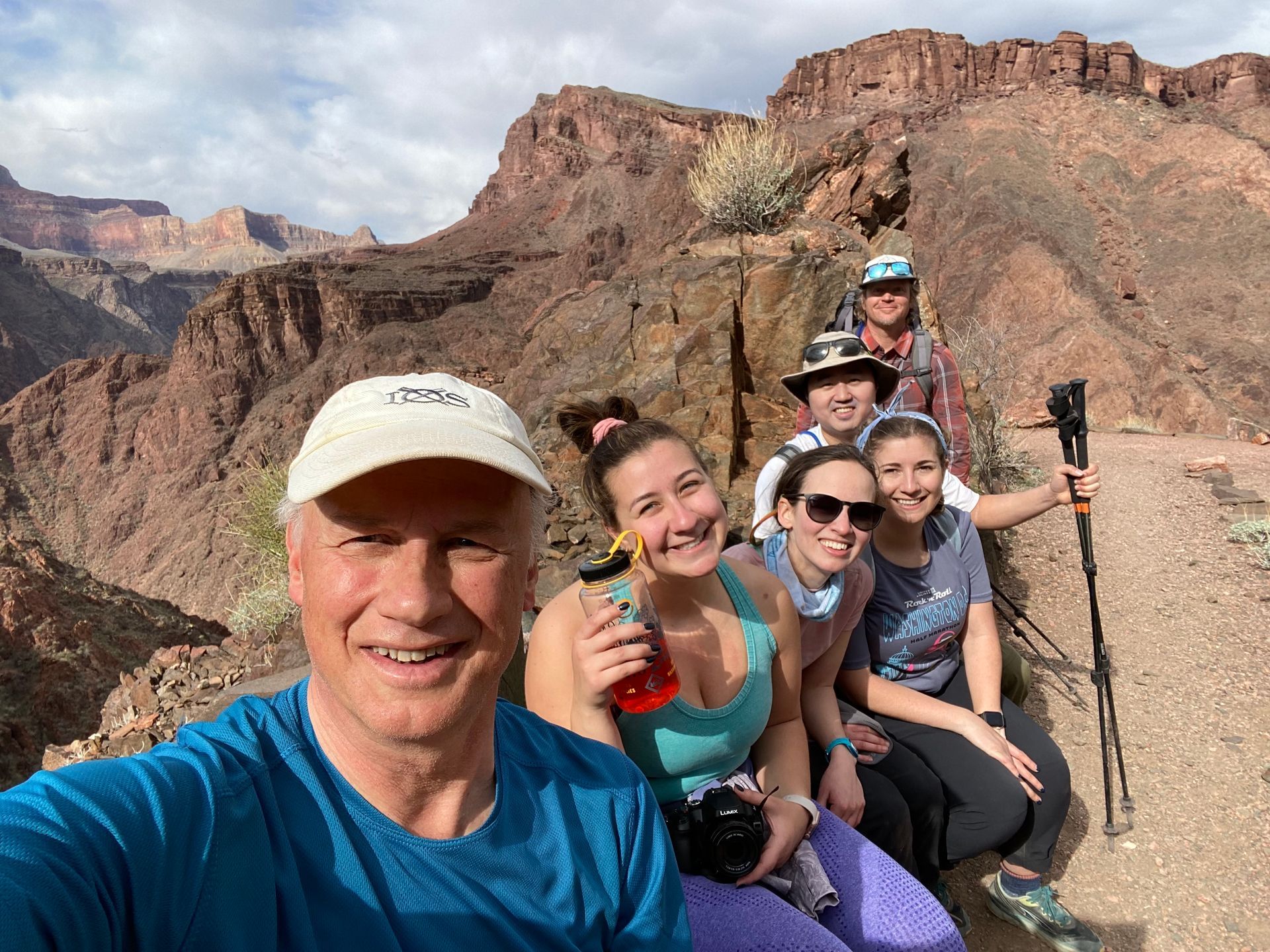 A group of people are taking a selfie in front of a mountain.