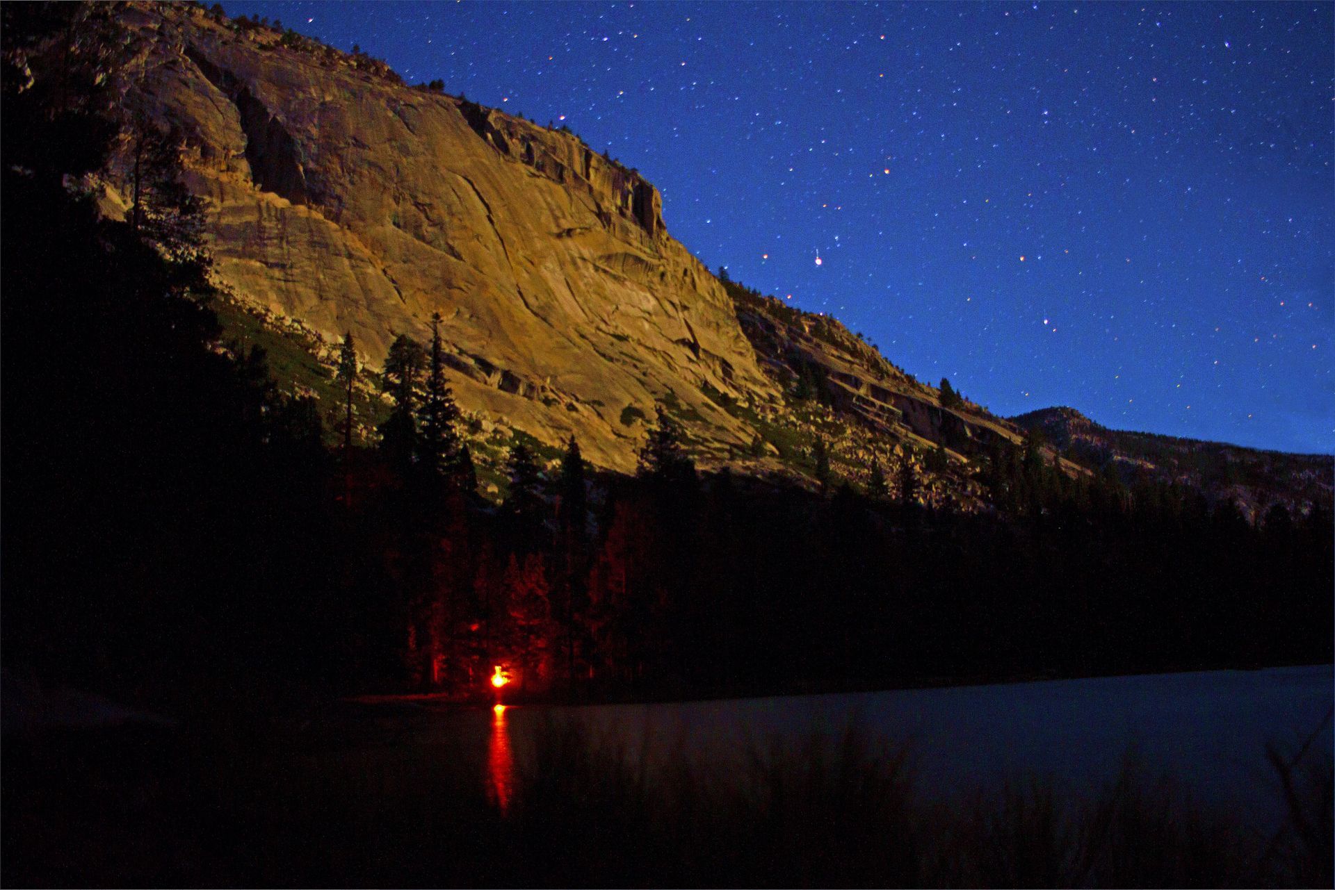 A lake with a mountain in the background at night