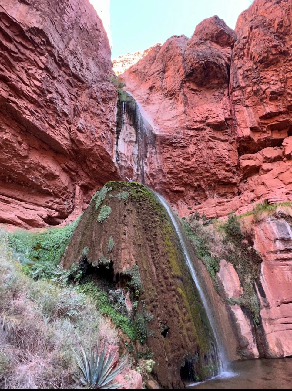 There is a waterfall in the middle of a canyon.