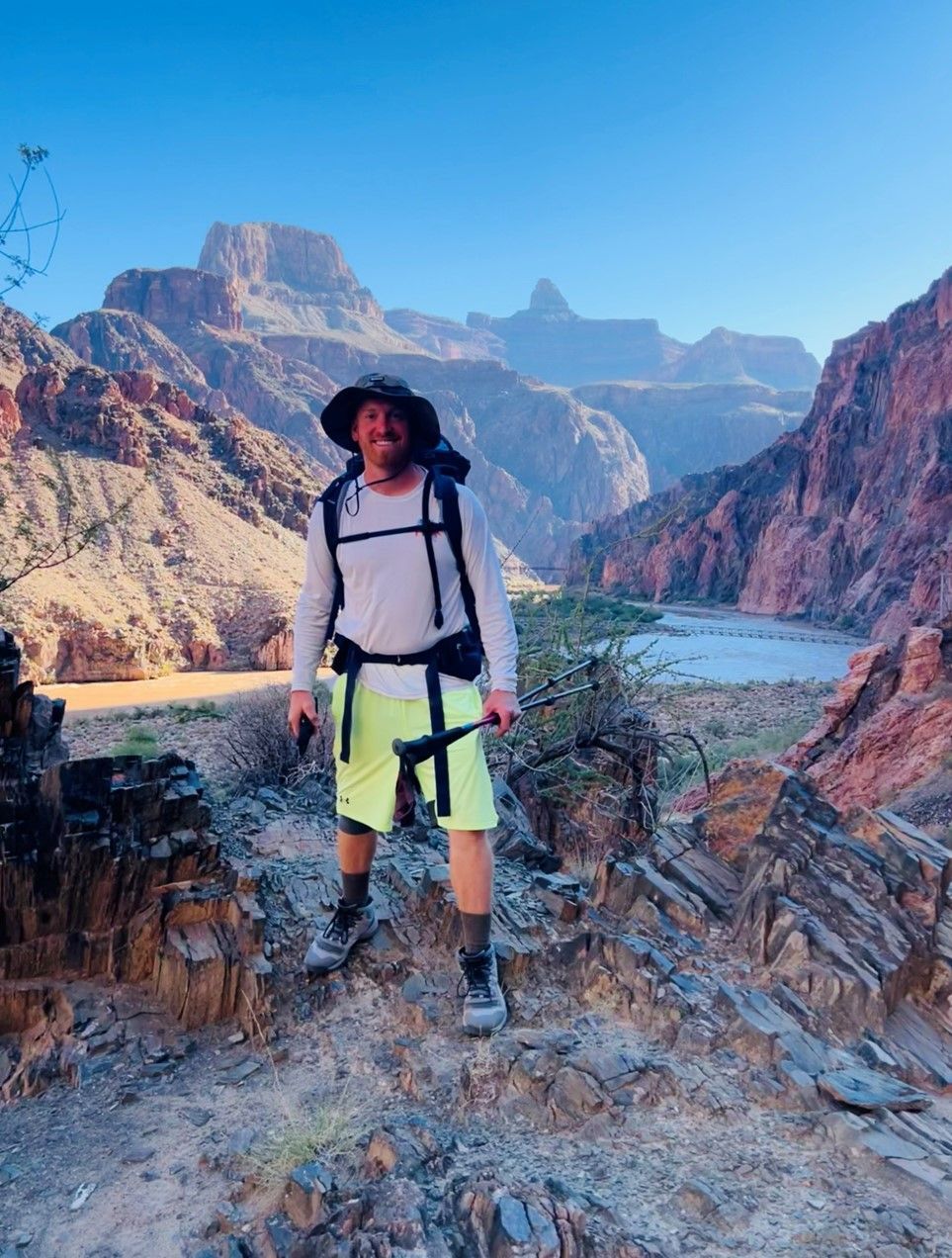 A man with a backpack is standing on top of a rocky mountain.
