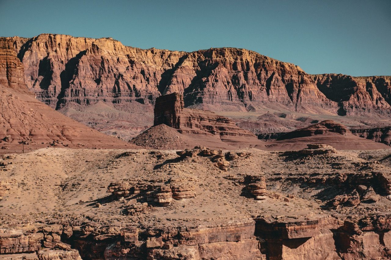 A desert landscape with mountains in the background and a blue sky