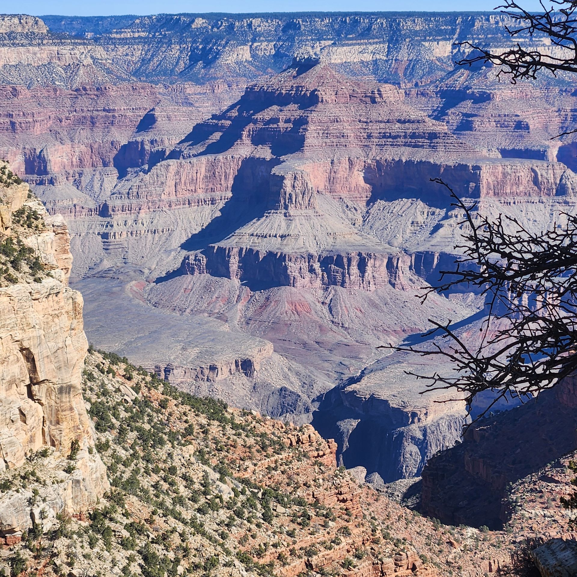 Grand Canyon view with layered rock formations under a clear sky.