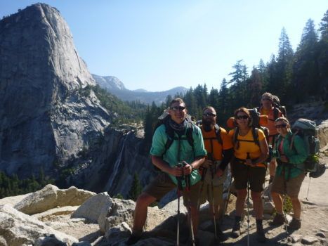 A group of people posing for a picture in front of a mountain