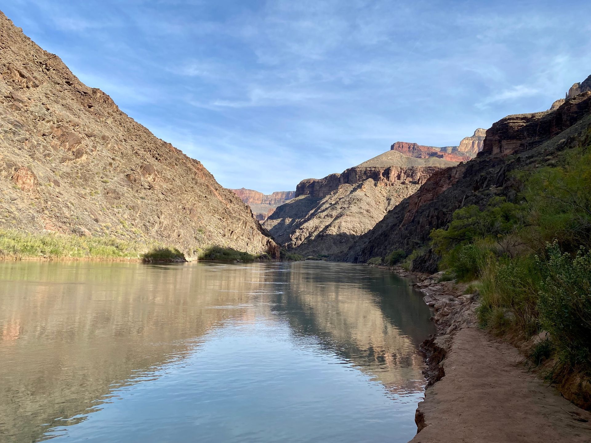 A river flowing through a canyon with mountains in the background.