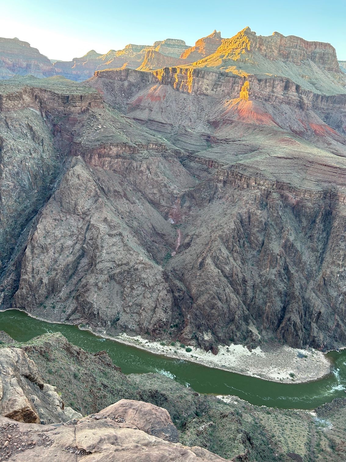 A river flowing through a canyon surrounded by mountains.