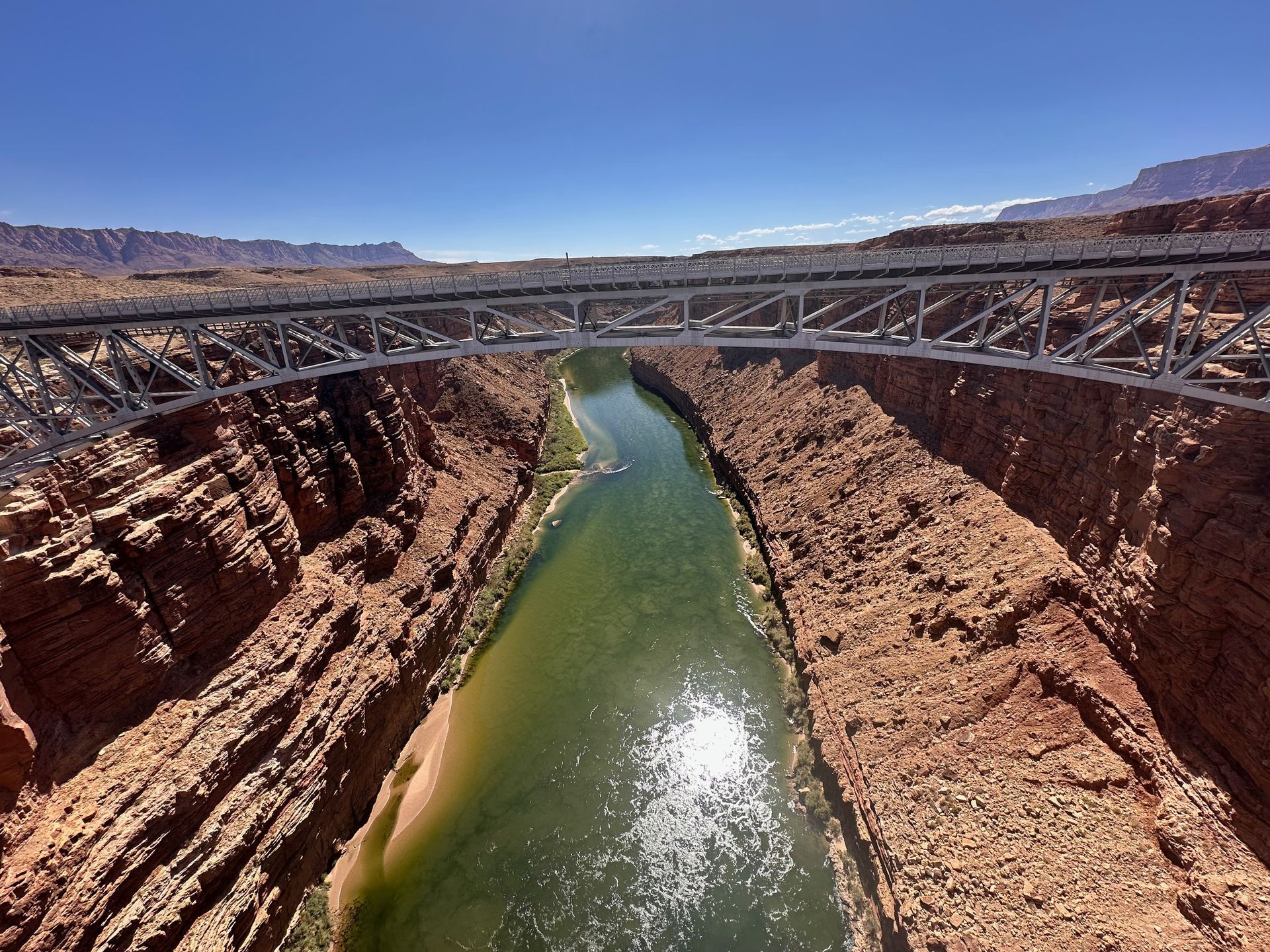 A bridge over a river with mountains in the background