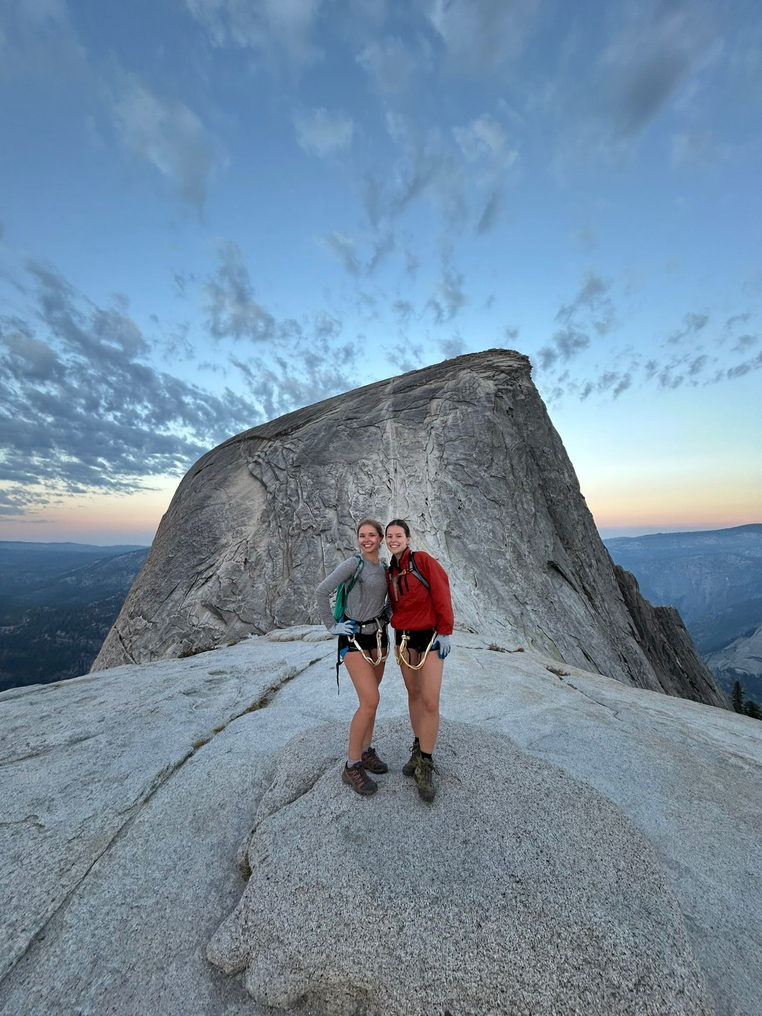 Two people are standing on top of a mountain.