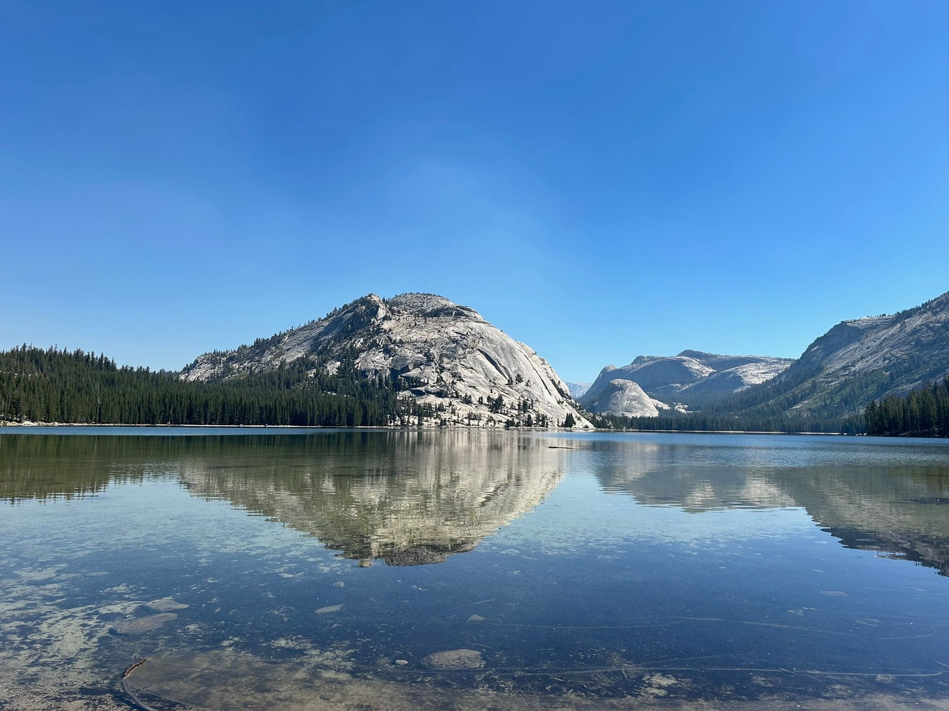 A lake with mountains in the background and a mountain reflected in the water.