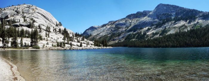 A lake with mountains in the background and trees on the shore.