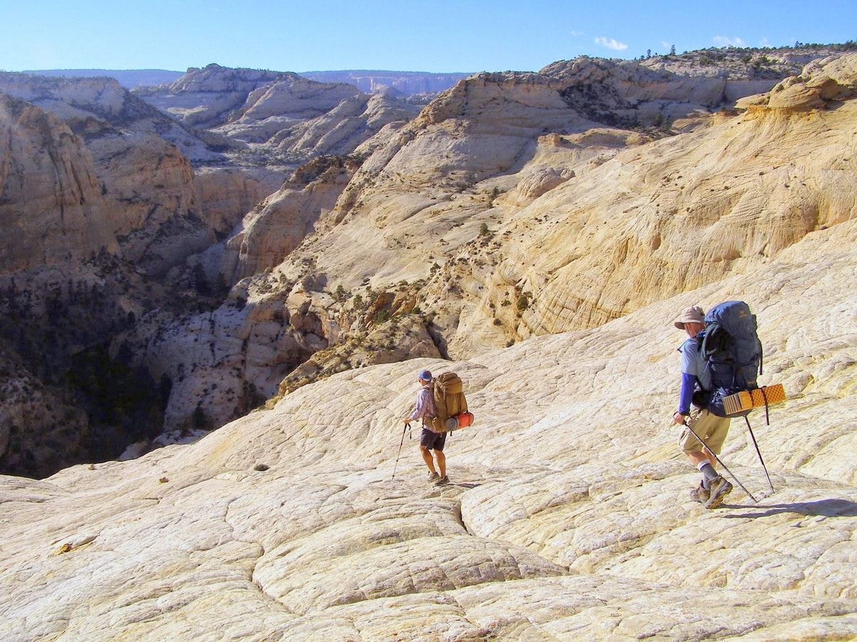 Two men are standing on top of a rocky hill