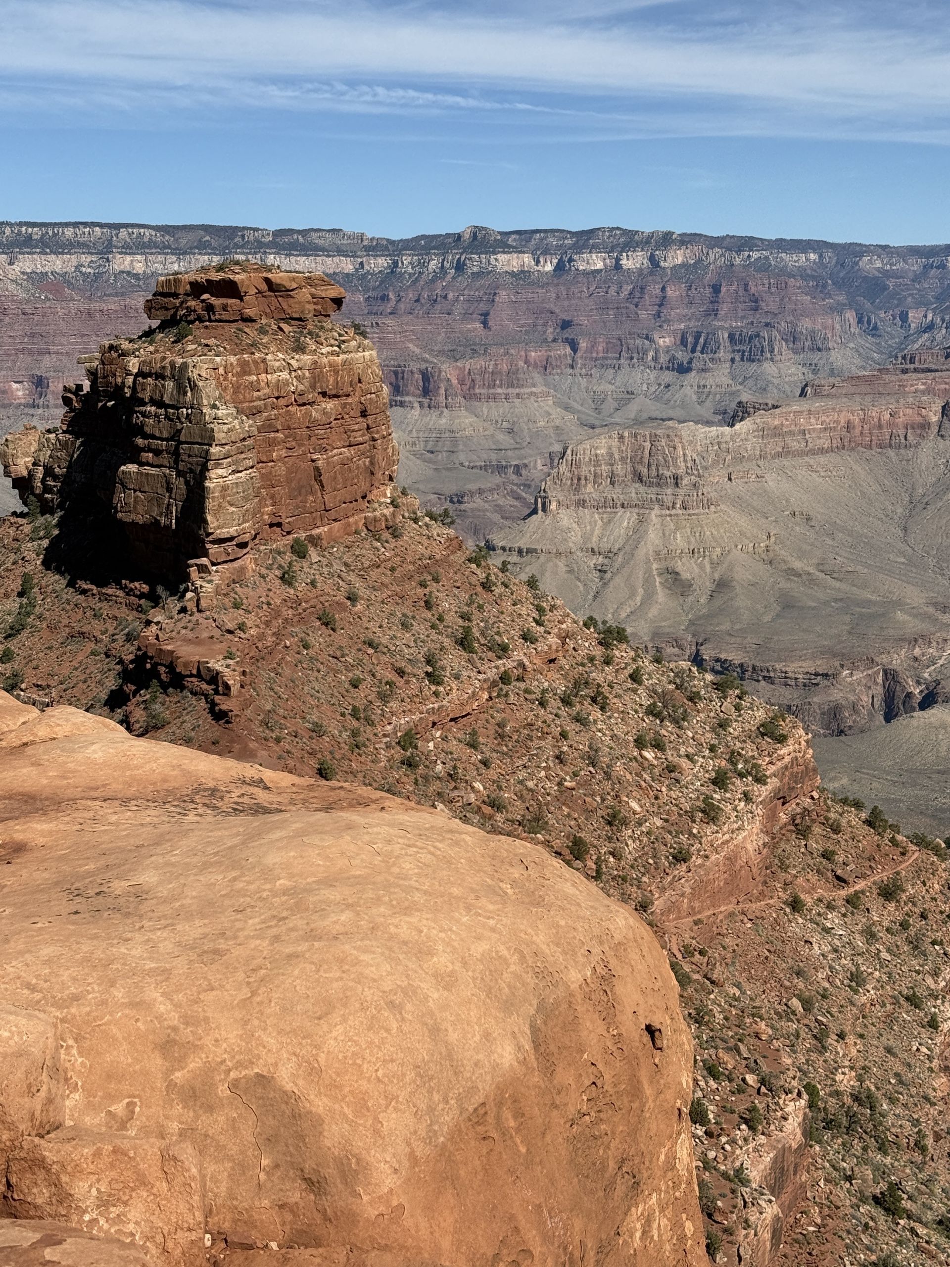 Grand Canyon vista with red rock formations and blue sky.