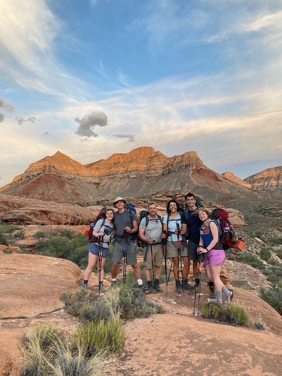 A group of people smiling in front of a majestic mountain