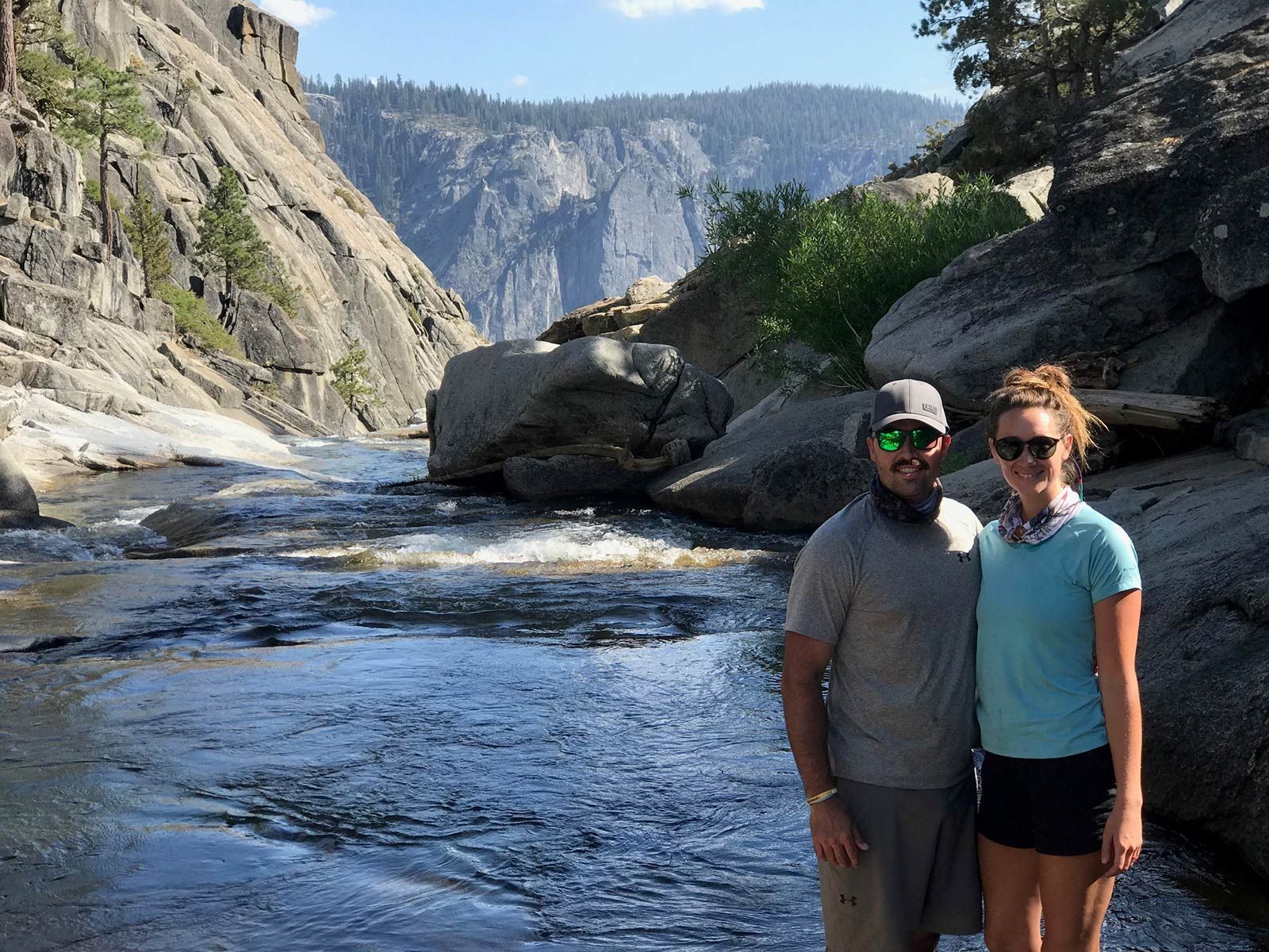 A man and a woman are standing next to a river.