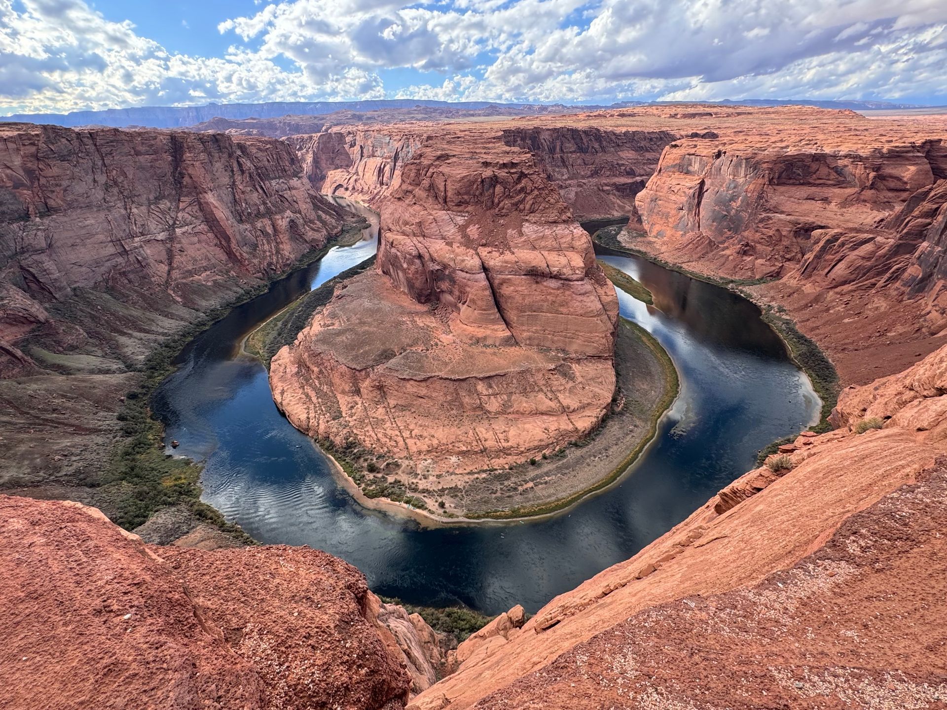 Horseshoe Bend: Red rock canyon with a turquoise river winding through it.