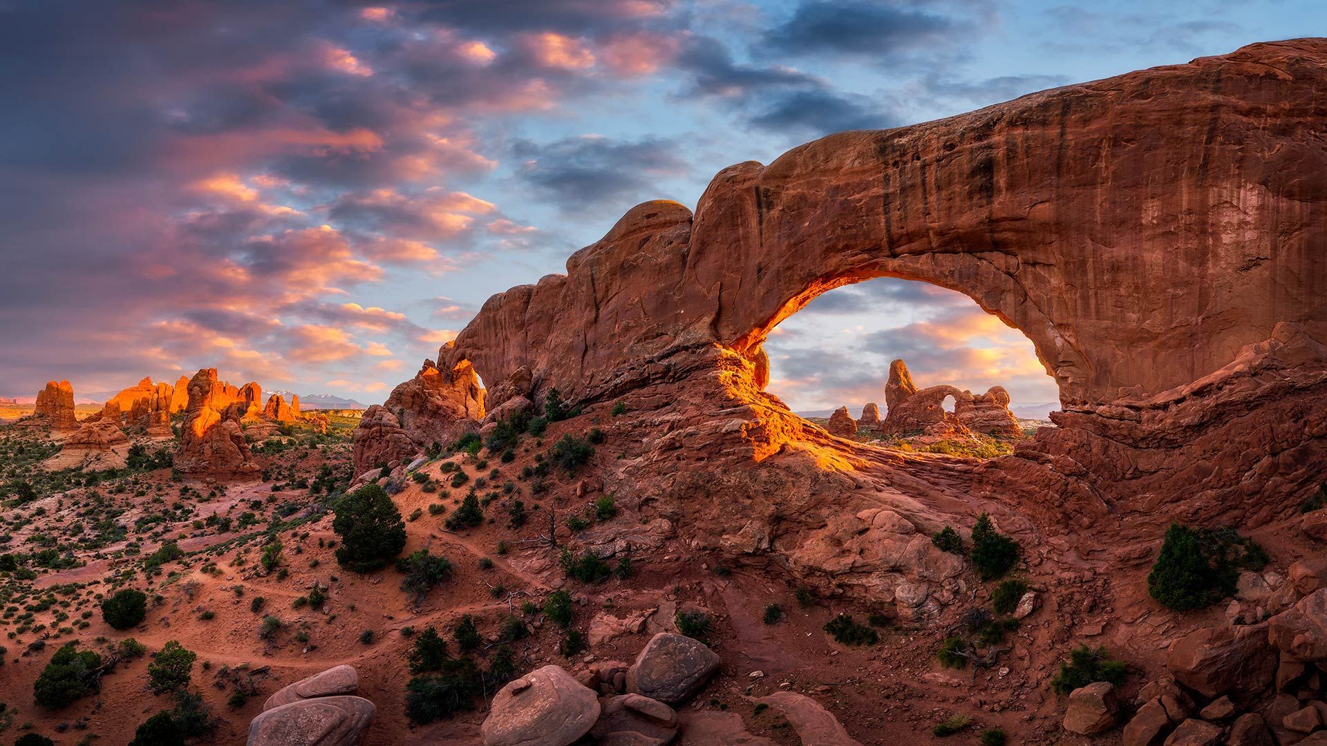 There is a large arch in the middle of the desert.