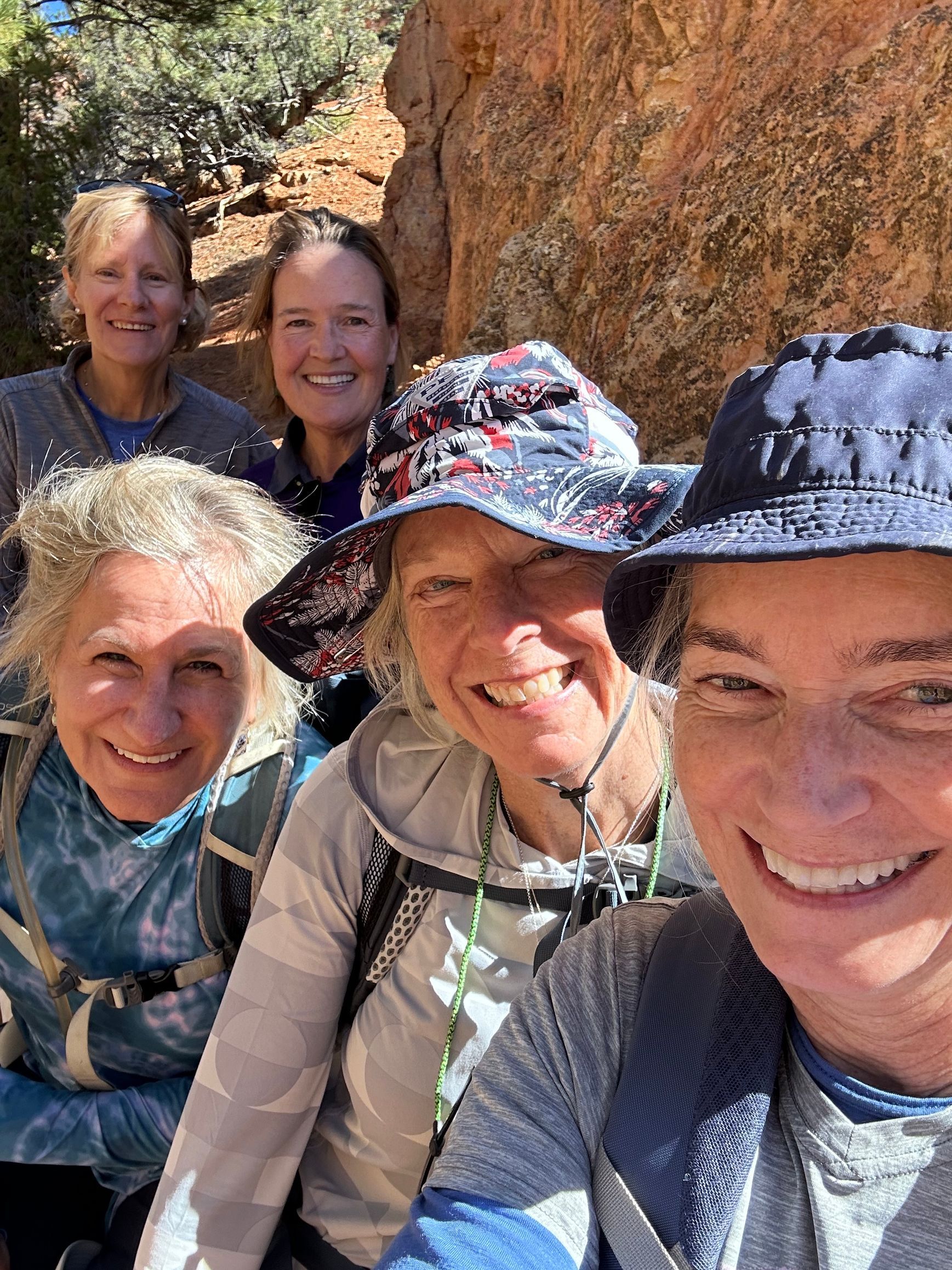 A group of women wearing hats are posing for a selfie.