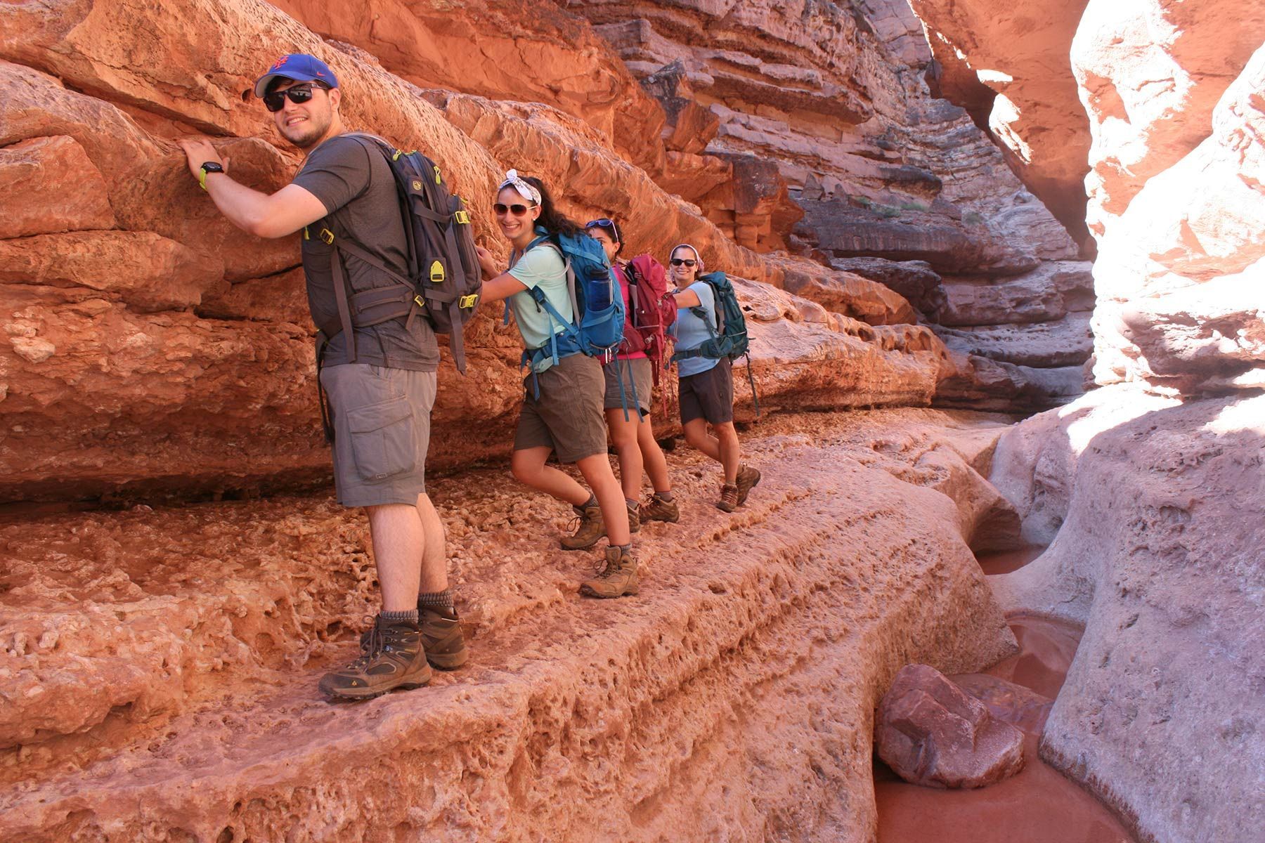 A group of people are hiking through a canyon.