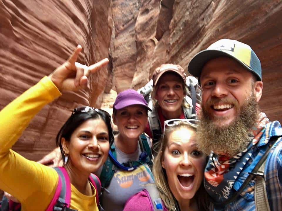 A group of people are posing for a picture in a canyon.