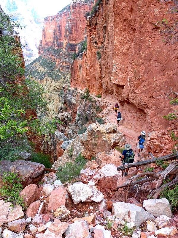 A group of people are hiking down a rocky trail.