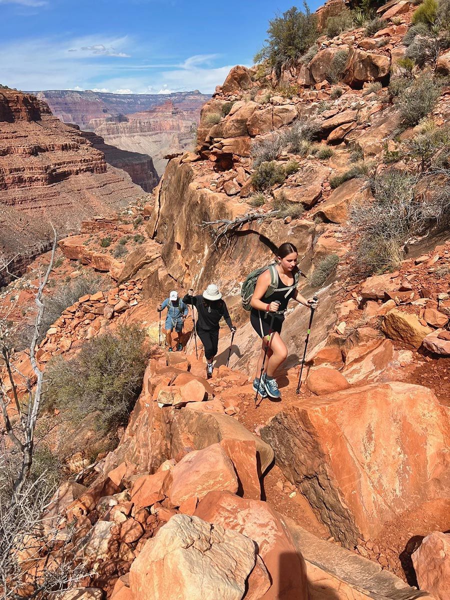 A group of people are hiking up a rocky mountain.